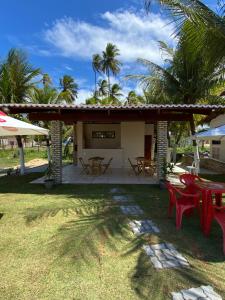 a patio with tables and chairs in a yard at Pousada Do Vozinho in Touros