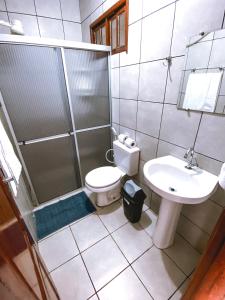 uma casa de banho com um chuveiro, um WC e um lavatório. em Pousada Do Vozinho em Touros