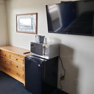 a microwave sitting on top of a refrigerator in a room at Fields Park Motel in Wisconsin Dells