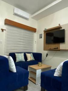 een woonkamer met twee blauwe banken en een tv bij Villa en Salinas vía Punta Carnero in Salinas
