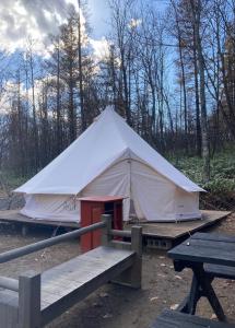 a large white tent with a table and benches at Pre Hub 十勝 