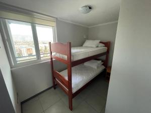 a small room with two bunk beds and a window at Apartamento junto a la playa en Bahía Horizonte in Coquimbo