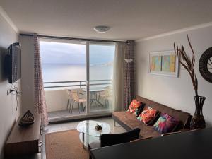 a living room with a couch and a view of the ocean at Apartamento junto a la playa en Bahía Horizonte in Coquimbo