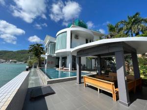 a house with a swimming pool next to the ocean at Nancy Grand Strip Villa Imperial 1 in Vung Tau