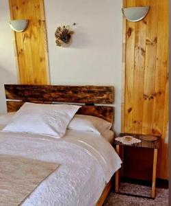 1 dormitorio con 1 cama con cabecero de madera en Casa cabaña, en Curarrehue