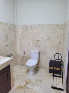 a bathroom with a toilet and a sink at Medewi Manor in Airsatang