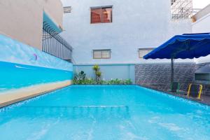 a large swimming pool with an umbrella next to a building at Villa Vũng Tàu - An Thảo Home's in Vung Tau