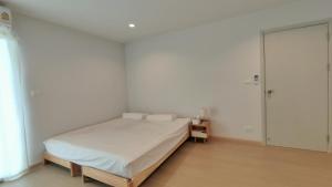 a white bedroom with a bed and a mirror at Cozy 1-bedroom condo close to MRT near JJ market in Bang Su