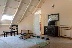 um quarto com uma cama grande e uma televisão em Yellow Tulip with Breakfast, BBQ Grill & Pet Home by StayVista em Coonoor