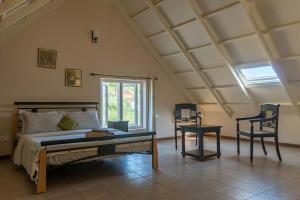 um quarto com uma cama, uma cadeira e uma janela em Yellow Tulip with Breakfast, BBQ Grill & Pet Home by StayVista em Coonoor