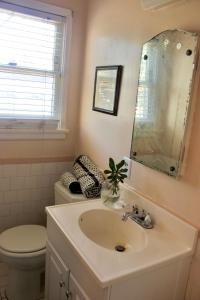 a bathroom with a sink and a toilet and a mirror at The Hi Point Estate in Los Angeles