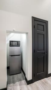 a kitchen with a black door and a refrigerator at Icon Inn in Ellensburg