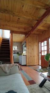 una sala de estar con paredes de madera y una escalera. en Casa cabaña, en Curarrehue