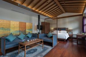 una camera d'albergo con letto, divano e tavolo di Beijing Heyuan Courtyard Hotel (Forbidden City) a Pechino