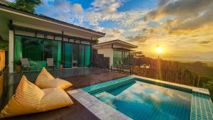 a villa with a swimming pool and a sunset at Caligo Resort in Ban Pha Saeng Lang