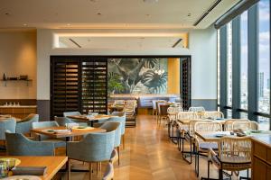 a restaurant with tables and chairs and windows at Osaka Excel Hotel Tokyu in Osaka