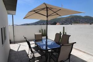un tavolo e sedie con ombrellone su un patio di HOSTAL XAO a Città di Oaxaca