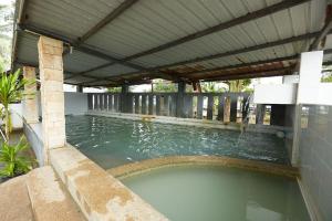 a large pool of water with a covered deck at Mawar Villa, Batu Hitam in Kuantan