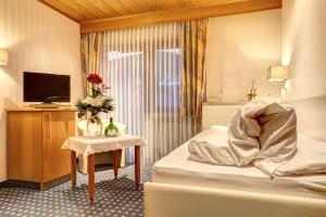 um quarto de hotel com uma cama e uma televisão em Zum Wiesengrund em Heimbuchenthal