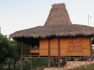 une petite cabane au toit de chaume dans l'établissement GUEST HOUSE, à Ndangu