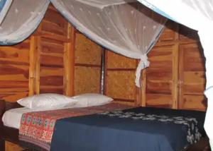 GUEST HOUSE في Ndangu: غرفة نوم بسرير مع مظلة