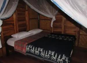 - une chambre avec un lit dans une pièce en bois dans l'établissement GUEST HOUSE, à Ndangu
