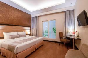 Una cama o camas en una habitación de Solaris Hotel Malang