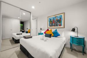1 dormitorio con 2 camas y espejo en StayCentral - Hawthorn East - Study, 2 Car spaces en Melbourne