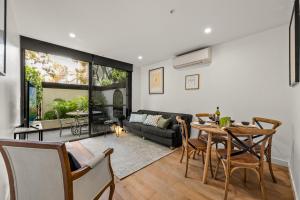 a living room with a table and a couch at StayCentral - Hawthorn East - Study, 2 Car spaces in Melbourne