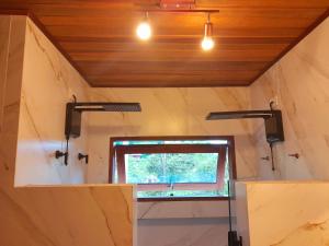 a bathroom with a window in a small room at Hakuna Studios Barra do Sahy in Barra do Sahy
