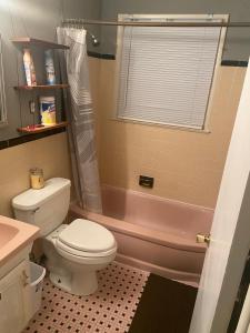a bathroom with a toilet and a sink and a tub at A Cozy Home Away From Home in Washington