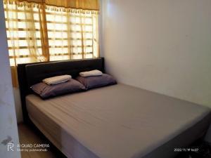 a bed in a room with two pillows on it at Sri Manik Guest House Tanjung Karang in Tanjung Karang
