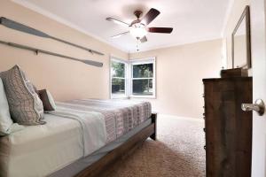 una camera da letto con un letto e un ventilatore a soffitto di Chain O Lakes Nautical 4Bed 3Bath Waterfront with Bonus Room, Large Deck and Hot Tub a Fox Lake