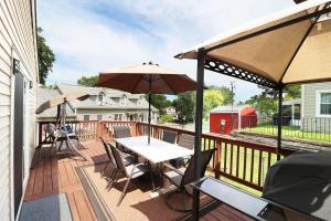 patio con tavolo e ombrellone su una terrazza di Chain O Lakes Nautical 4Bed 3Bath Waterfront with Bonus Room, Large Deck and Hot Tub a Fox Lake