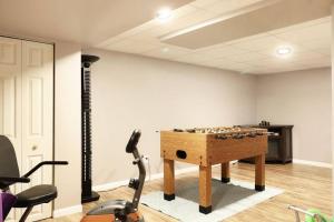 una stanza con un biliardino e un tapis roulant di Chain O Lakes Nautical 4Bed 3Bath Waterfront with Bonus Room, Large Deck and Hot Tub a Fox Lake