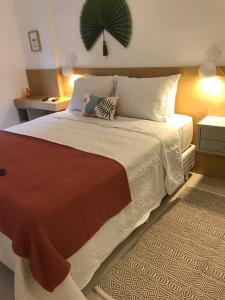 里約熱內盧的住宿－LUXUOSO QUARTO SALA LEBLON，一间卧室配有一张大床,铺有红白毯子