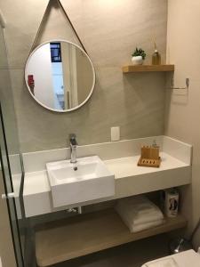 a bathroom with a sink and a mirror at LUXUOSO QUARTO SALA LEBLON in Rio de Janeiro