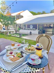 einen Tisch mit Speisen und Getränken darauf in der Unterkunft Tree Tara hotel -- SHA Plus in Lampang