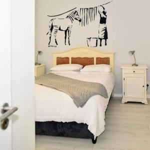 a bedroom with a bed with a zebra on the wall at On The Beach at Surfers Corner in Cape Town