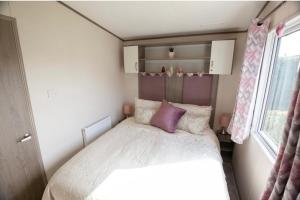 ein kleines Schlafzimmer mit einem Bett und einem Fenster in der Unterkunft Pepper Pot Lodge in Knaresborough