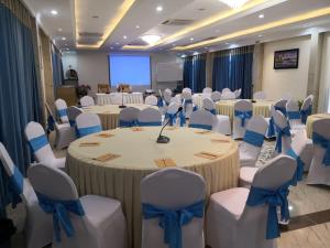 a banquet hall with tables and chairs with blue bows at Lodge Moni Essara Kampot in Kampot