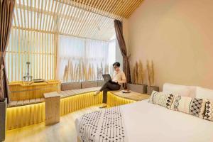 einem Mann, der auf einem Fenstersitz mit einem Laptop sitzt in der Unterkunft HomestayCHAT*TropicalHome1*OldQuarter*Hanoi in Hanoi