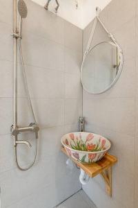 ein Badezimmer mit einer Schüssel auf einem Regal und einem Spiegel in der Unterkunft HomestayCHAT*TropicalHome1*OldQuarter*Hanoi in Hanoi