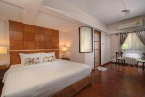 a bedroom with a large bed and a dining room at Estia Chiangmai -SHA Plus in Chiang Mai