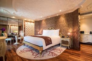 a bedroom with a large bed and a dining room at The Reverie Saigon in Ho Chi Minh City