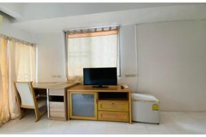 a room with a desk with a television and a table at OYO 75418 Grandview Place in Bangkok