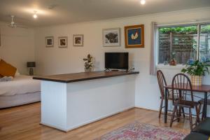 a living room with a kitchen with a bar and a bed at Bower On Becket - Couples Retreat in Rye