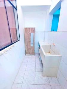 baño con aseo y lavabo y ventana en Casa de Playa Barranca, en Barranca