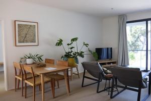 洛恩Lorne Surf Apartments的带餐桌和椅子的客厅