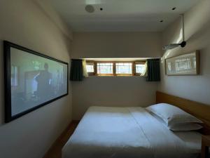 una camera con un letto con una foto sul muro di Beijing Heyuan Courtyard Hotel (Forbidden City) a Pechino